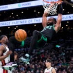 Celtics guard Jaylen Brown slams a dunk against Miami Heat center Bam Adebayo during the first half.