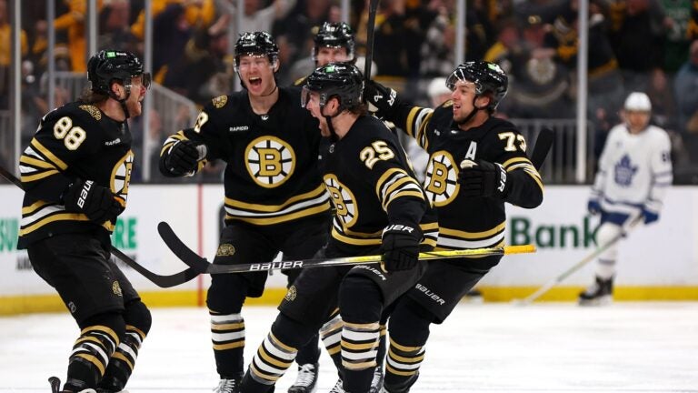 BOSTON, MASSACHUSETTS - MAY 04: David Pastrnak #88 of the Boston Bruins celebrates with Brandon Carlo #25, Charlie McAvoy #73 and John Beecher #19 after scoring the game winning goal against the Toronto Maple Leafs during overtime to win Game Seven of the First Round of the 2024 Stanley Cup Playoffs at TD Garden on May 04, 2024 in Boston, Massachusetts.