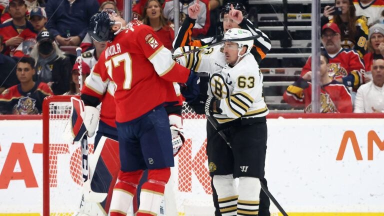 SUNRISE, FLORIDA - MARCH 26: Niko Mikkola #77 of the Florida Panthers and Brad Marchand #63 of the Boston Bruins battle during the second period at Amerant Bank Arena on March 26, 2024 in Sunrise, Florida.