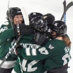 Boston forward Jamie Lee Rattray, left, forward Taylor Wenczkowski, center, and defenseman Jess Healey, right, celebrate with teammates after Boston scored during the second period in Game 1 of a PWHL hockey championship series, Sunday, May 19, 2024, in Lowell, Mass.