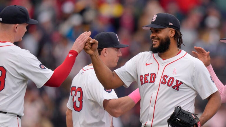 Boston Red Sox's Kenley Jansen, right, celebrates with Garrett Cooper, left, and Romy Gonzalez, center, after they defeated the Washington Nationals in a baseball game, Sunday, May 12, 2024, in Boston.