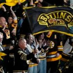 Former Boston Bruins player Tim Thomas (30) waves a flag before Game 6 of an NHL hockey Stanley Cup second-round playoff series against the Florida Panthers, Friday, May 17, 2024, in Boston.