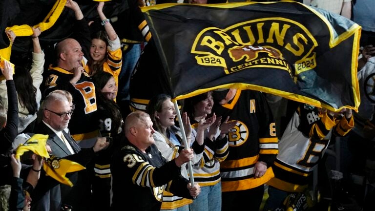 Former Boston Bruins player Tim Thomas (30) waves a flag before Game 6 of an NHL hockey Stanley Cup second-round playoff series against the Florida Panthers, Friday, May 17, 2024, in Boston.