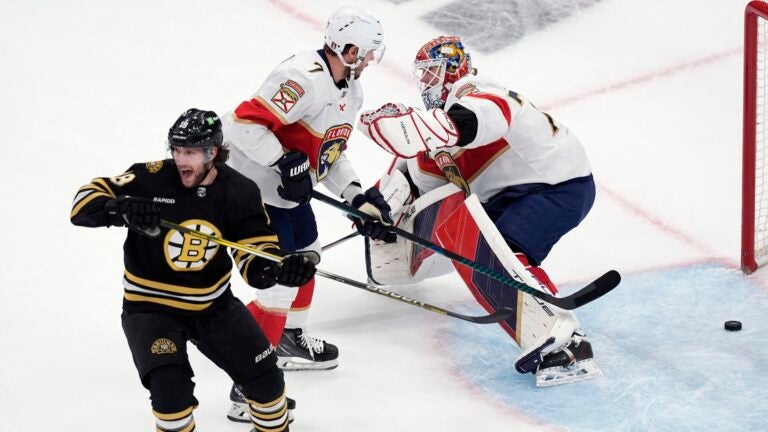 Boston Bruins' Pavel Zacha (18) celebrates after a goal by Brandon Carlo (not shown) in front of Florida Panthers' Dmitry Kulikov (7) and Sergei Bobrovsky, right, during the first period in Game 4 of an NHL hockey Stanley Cup second-round playoff series, Sunday, May 12, 2024, in Boston.