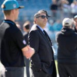 Carolina Panthers vice president of football administration Samir Suleiman, center, watches players warm up in December 2023.