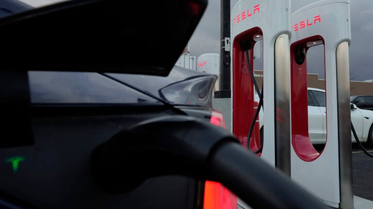 FILE - A vehicle charges at a Tesla Supercharger station in Detroit, Nov. 16, 2022.