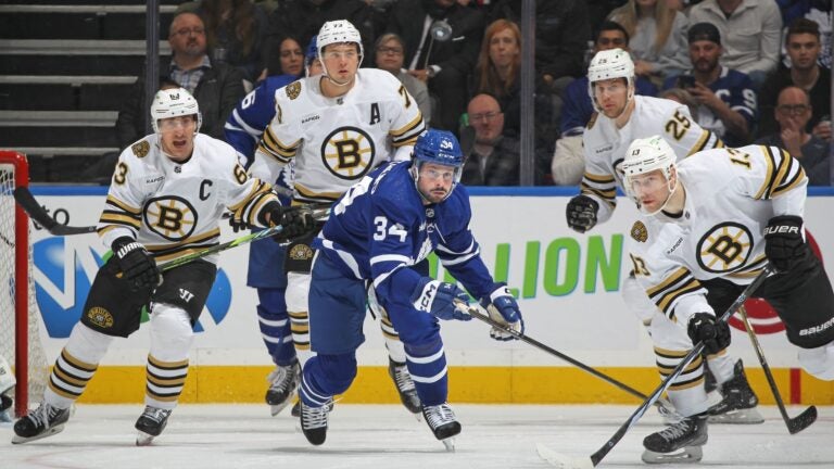 TORONTO, CANADA - MARCH 4: Auston Matthews #34 of the Toronto Maple Leafs keeps an eye on a high puck with Charlie Coyle #13 of the Boston Bruins during the first period in an NHL game at Scotiabank Arena on March 4, 2024 in Toronto, Ontario, Canada. The Bruins defeated the Maple Leafs 4-1.