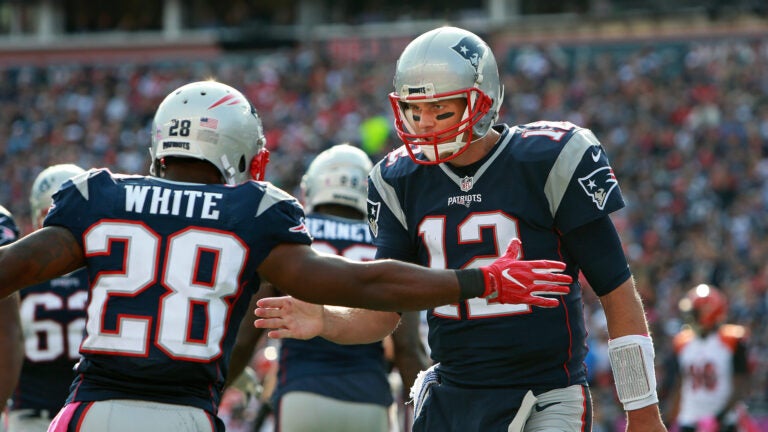 Patriots quarterback Tom Brady (right) celebrates with running back James White (left) after they hooked up for a third quarter touchdown pass, their second of the game. Gillette Stadium Cincinnati Bengals at New England Patriots - 3rd quarter action.