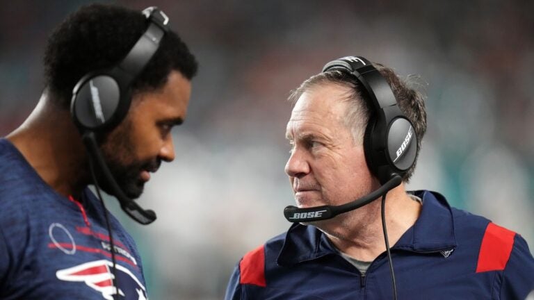 Jerod Mayo and Bill Belichick talk on the sidelines during a game against the Miami Dolphins in 2022. Mayo recently took over for Belichick as head coach of the New England Patriots.