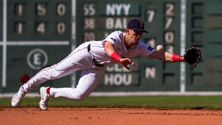 Zack Short dives for a ground ball as it bounds past him.