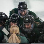 Players huddle up to listen to PWHL Boston head coach Courtney Kessell during a timeout in the first period. The PWHL Boston host PWHL Minnesota in Game 5 of the PWHL Finals at Tsongas Arena.