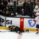 Boston Bruins left wing Brad Marchand (63) goes down hard in front of his bench against the Florida Panthers during first period action in game three of the Eastern Conference NHL second round Playoff game at TD Garden.