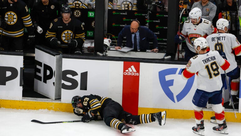 Boston Bruins left wing Brad Marchand (63) goes down hard in front of his bench against the Florida Panthers during first period action in game three of the Eastern Conference NHL second round Playoff game at TD Garden.