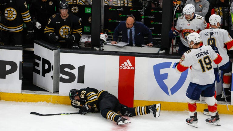 Boston Bruins left wing Brad Marchand (63) goes down hard in front of his bench against the Florida Panthers during first period action in game three of the Eastern Conference NHL second round Playoff game at TD Garden.