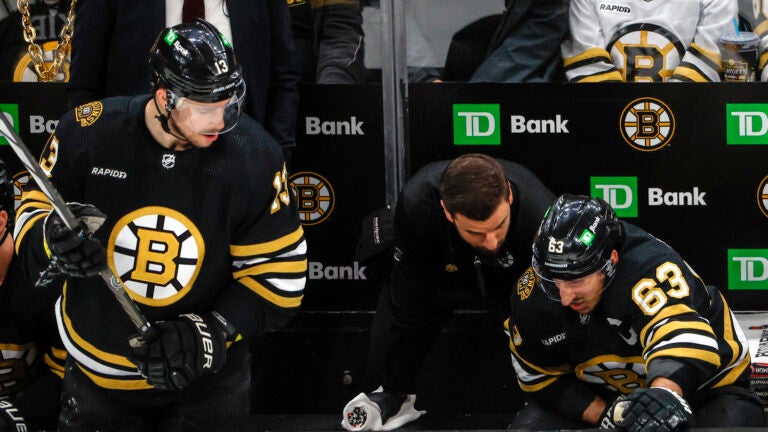 Boston Bruins Dustin Stuck head athletic trainer checking in on left wing Brad Marchand (63) who was injured after a hit by Florida Panthers center Sam Bennett (9) during first period action in game three of the Eastern Conference NHL second round Playoff game at TD Garden.
