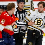 Refere Garrett Rank (7) separate Boston Bruins defenseman Charlie McAvoy (73) and Florida Panthers defenseman Niko Mikkola (77) during third period action in game two of the Eastern Conference NHL second round Playoff game at Amerant Bank Arena.