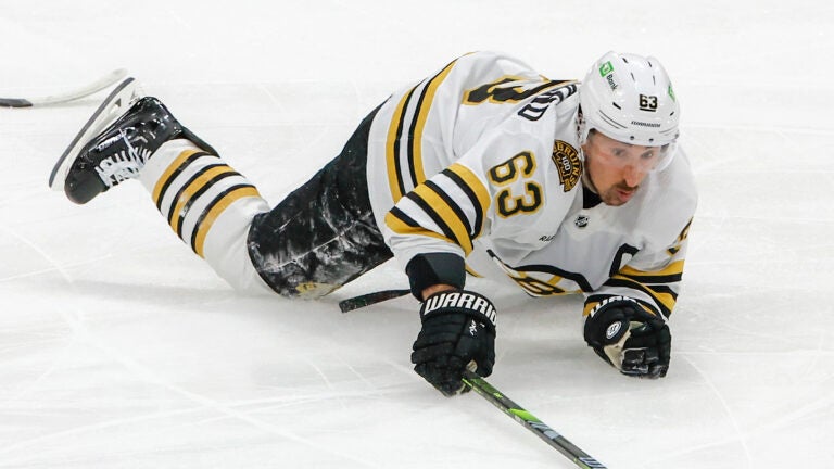 Boston Bruins left wing Brad Marchand (63) controls the puck after getting tripped and penalized by Florida Panthers center Anton Lundell (15) during first period of game two of the Eastern Conference NHL second round Playoff game at Amerant Bank Arena.