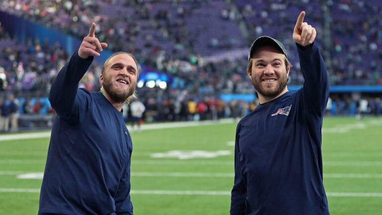 Steve Belichick (left) and his brother Brian Belichick (right), the sons of Patriots head coach Bill Belichick, smile and point to some friends in the stands who were calling out to them around two hours before kickoff. The New England Patriots play the Philadelphia Eagles in Super Bowl LII at US Bank Stadium in Minneapolis.