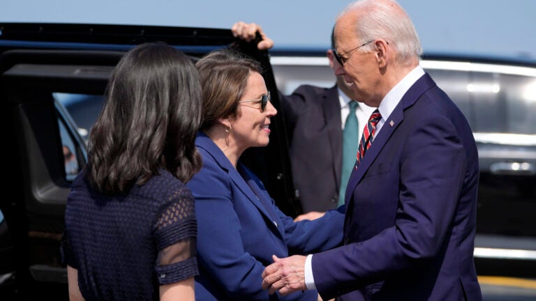 President Joe Biden Greets Massachusetts Gov. Maura Healey, center, as Boston Mayor Michelle Wu, left, watches, as he arrives on Air Force One at Boston-Logan International Airport, Tuesday, May 21, 2024.