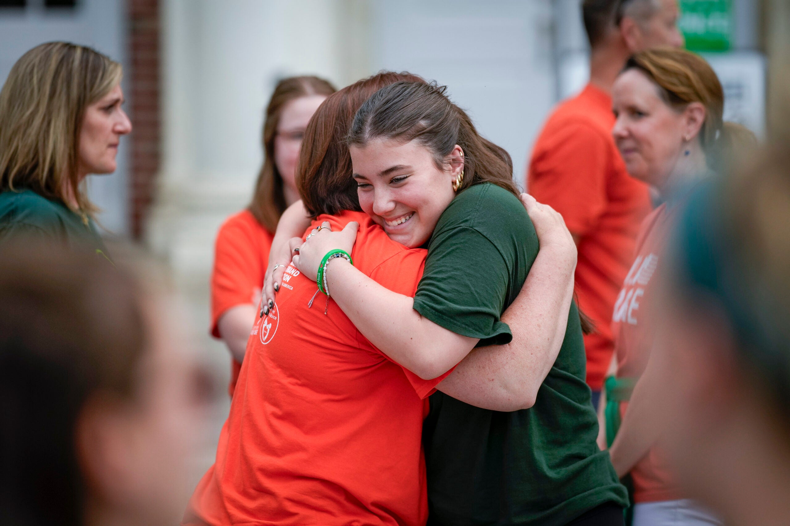 Emma Ehrens, a survivor of the 2012 Sandy Hook Elementary School shooting, hugs a family friend.