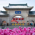 Tourists walk past a gateway with the name "Beishan" seen at the Beishan Park in northeastern China's Jilin province.