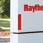 A sign stands at the road leading to the Raytheon facility in Marlborough, Mass.
