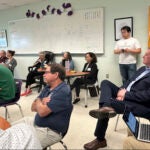 Ed Augustus, seated, right, the Massachusetts State Secretary of Housing and Livable Communities, listens to concerns about housing.