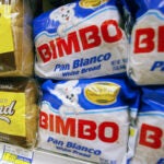 Bimbo bread is displayed on a shelf at a market.