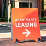 Apartment leasing sign promote the rental property and shows direction where the rental office is located. broker