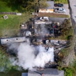 Auburn firefighters hose down the remains of home in Auburn, Maine, early Saturday, June 15, 2024.