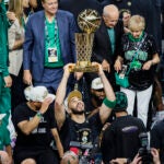 Boston Celtics forward Jayson Tatum (0) holds up the Larry O'Brien Championship Trophy after winning the NBA Finals. The Boston Celtics hosted the Dallas Mavericks at TD Garden on Monday, June 17, 2024.