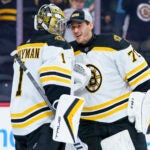 Boston Bruins' Jeremy Swayman, left, celebrates the win with Brandon Bussi, right, during the 3rd period of an NHL hockey game against the Philadelphia Flyers, Sunday, April 9, 2023, in Philadelphia. The Bruins won 5-3.