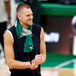 Boston Celtics center Kristaps Porzingis tapes his right wrist as he walks onto the court for practice at TD Garden on Wednesday.