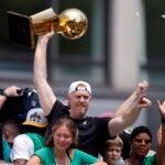 Former Boston Celtic Brian Scalabrine holds the Larry O’Brien championship trophy from the 2008 NBA Finals during a duck boat parade to celebrate the 18th Boston Celtics NBA championship on Friday, June 21, 2024. The Celtics defeated the Dallas Mavericks in Game 5 of the NBA Finals.