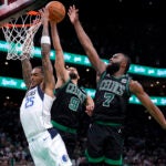 Dallas Mavericks forward P.J. Washington (25) is blocked by Boston Celtics' Derrick White (9) and Jaylen Brown (7) during the second half of Game 2 of the NBA Finals basketball series, Sunday, June 9, 2024, in Boston.