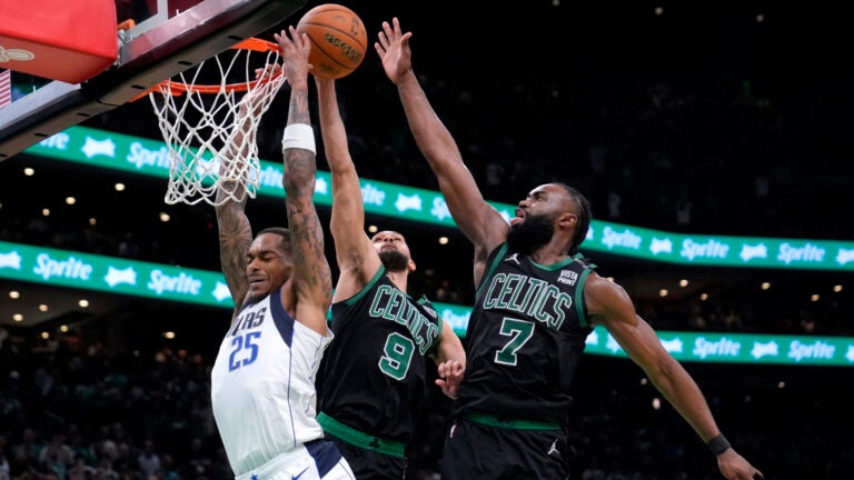 Dallas Mavericks forward P.J. Washington (25) is blocked by Boston Celtics' Derrick White (9) and Jaylen Brown (7) during the second half of Game 2 of the NBA Finals basketball series, Sunday, June 9, 2024, in Boston.