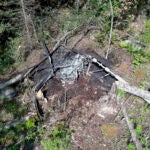 In this aerial photo released by New Hampshire State Police, the remains of a helicopter that crashed and caught fire are seen on Saturday, June 1, 2024, Danbury, N.H. The pilot, who was not identified, survived the crash.