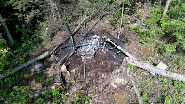 In this aerial photo released by New Hampshire State Police, the remains of a helicopter that crashed and caught fire are seen on Saturday, June 1, 2024, Danbury, N.H. The pilot, who was not identified, survived the crash.