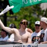 Boston Celtics forward Sam Hauser waves his shirt over his head during the duck boat parade to celebrate the 18th Boston Celtics NBA championship on Friday, June 21, 2024. The Celtics defeated the Dallas Mavericks in Game 5 of the NBA Finals.
