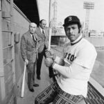 FILE- Orlando Cepeda, right, swings a bat for photographers after the Boston Red Sox announced they had signed Cepeda as their first designated hitter, at Fenway Park in Boston.