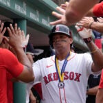 Rafael Devers of the Red Sox celebrates with teammates in the dugout after scoring on his two-run home run in the first inning.