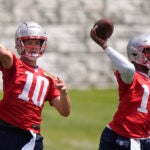 New England Patriots quarterbacks Drake Maye (10) and Jacoby Brissett (14) pass during an NFL football practice, Wednesday, June 12, 2024, in Foxborough, Mass.