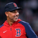 Boston Red Sox manager Alex Cora smiles while heading back to the dugout during the eighth inning of the team's baseball game against the Philadelphia Phillies, Wednesday, June 12, 2024, in Boston.