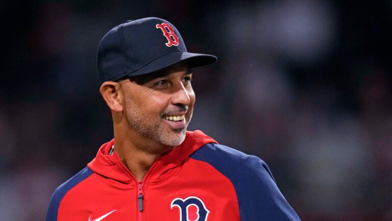 Boston Red Sox manager Alex Cora smiles while heading back to the dugout during the eighth inning of the team's baseball game against the Philadelphia Phillies, Wednesday, June 12, 2024, in Boston.