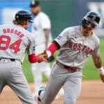 Boston Red Sox third base coach Kyle Hudson greets Jarren Duran at third after Duran's home run off Chicago White Sox starting pitcher Jake Woodford during the first inning.