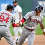 Boston Red Sox third base coach Kyle Hudson greets Jarren Duran at third after Duran's home run off Chicago White Sox starting pitcher Jake Woodford during the first inning.