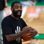 BOSTON, MASSACHUSETTS - JUNE 05: Kyrie Irving #11 of the Dallas Mavericks smiles during the 2024 NBA Finals Media Day at TD Garden on June 05, 2024 in Boston, Massachusetts.