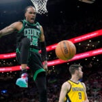 Boston Celtics forward Oshae Brissett (12) celebrates after dunking against the Indiana Pacers during the second half of Game 2 of the NBA Eastern Conference basketball finals Thursday, May 23, 2024, in Boston.