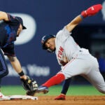 Red Sox player steals second base, stretching with his leg to touch the base.