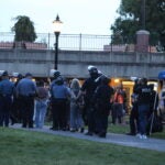 Police took students away in plastic handcuffs on the UMass Amherst campus Tuesday night after protesters set up an encampment outside the student union.